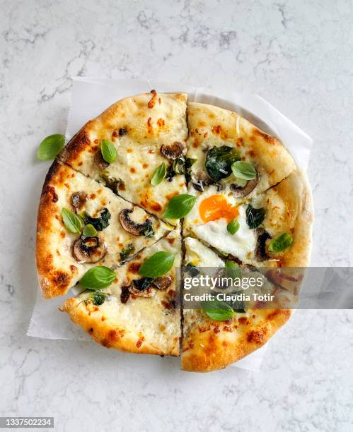 pizza with truffle oil, mushrooms, and eggs on white, marble background - repas servi photos et images de collection