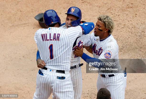 Javier Baez of the New York Mets celebrates after scoring the game winning run in the ninth inning against the Miami Marlins with teammates Jonathan...