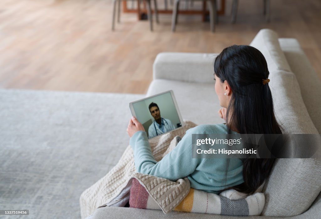Woman at home feeling poorly and talking to her doctor on a video call