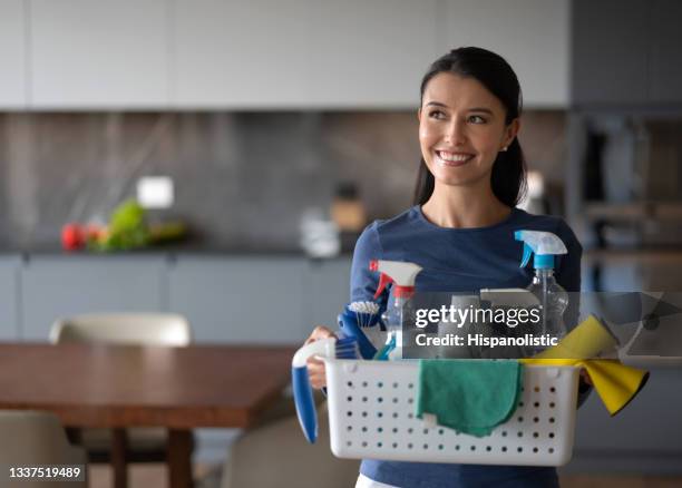 femme heureuse à la maison tenant un panier de produits de nettoyage - agent de ménage photos et images de collection