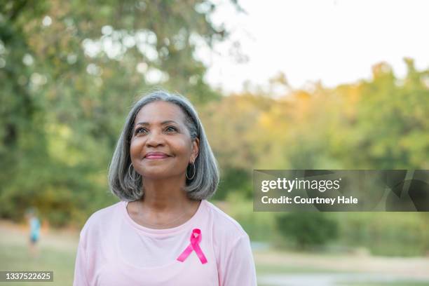 beautiful senior woman smiles while walking for breast cancer awareness - bröstcancer bildbanksfoton och bilder