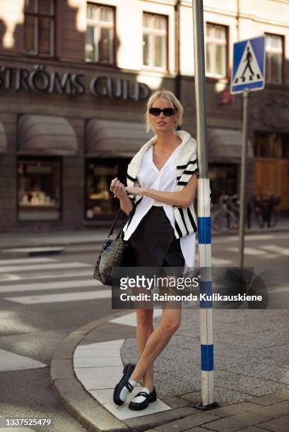 Caroline Winberg wearing black skirt, white shirt, striped black and white sweater and black and white shoes outside House of Dagmar during Stockholm...