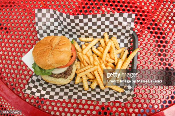 hamburger and french fries on tray outdoors - fastfood restaurant table stock-fotos und bilder