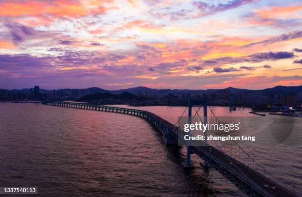 aerial view of xinghai bay bridge against a dramatic sky. - juice driving stock pictures, royalty-free photos & images