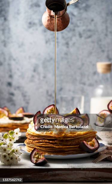 hand made crepes with whipped cream, maple syrup  and passion fruit - chef smelling food stockfoto's en -beelden
