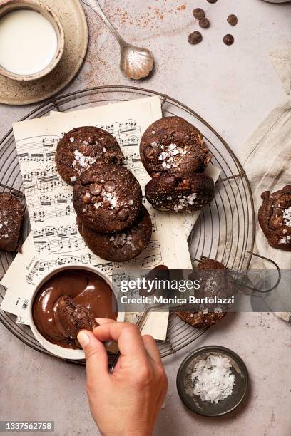 handmade chocolate cookies with sea salt flakes, human hands - dips stock pictures, royalty-free photos & images