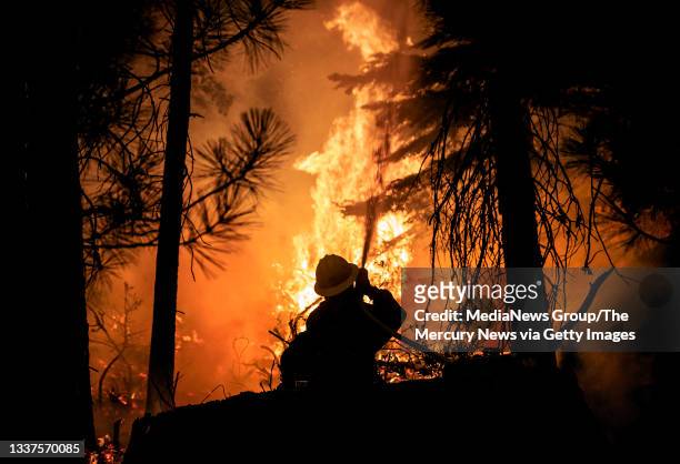 Aug. 28: A firefighter with the U.S. Forest Service protects the Strawberry General Store on Highway 50 in El Dorado County after a backfire was set,...
