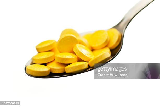 a spoonful of multivitamin tablets isolated on a white background - vitamin a stock pictures, royalty-free photos & images