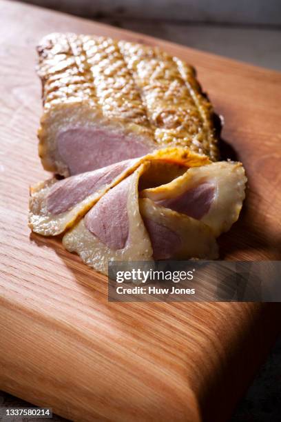 close up cured duck breast on a wooden board - lebensmittel trocknen stock-fotos und bilder