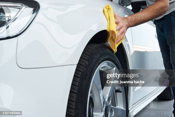 close up view of a worker detailing polishing a white car with a rag. - car wash photos et images de collection