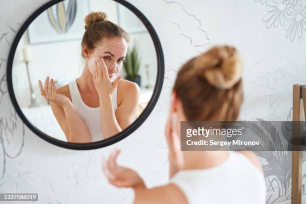 woman cleaning face with cosmetic product - beautification fotografías e imágenes de stock