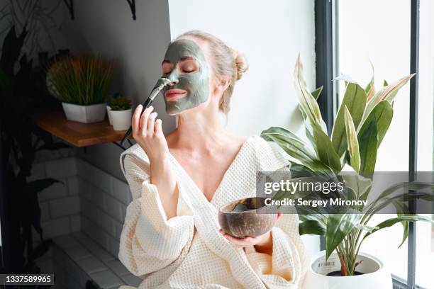 woman enjoying skin care treatment at home - wohlbefinden stock-fotos und bilder