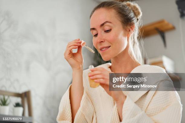 young woman with essential oil - etherische olie stockfoto's en -beelden