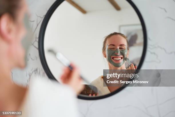 happy woman applying clay mask - clay mask ストックフォトと画像