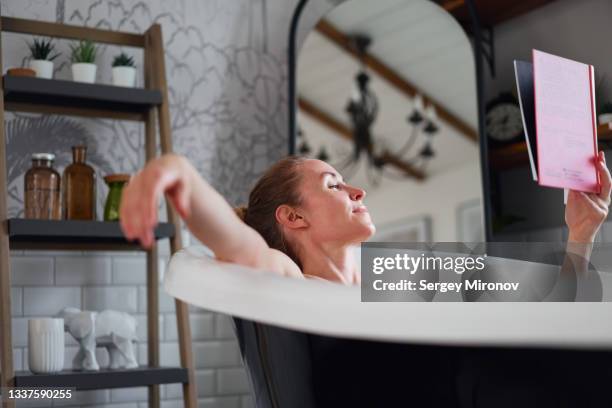 woman with book relaxing in bathtub - beautiful woman bath photos et images de collection