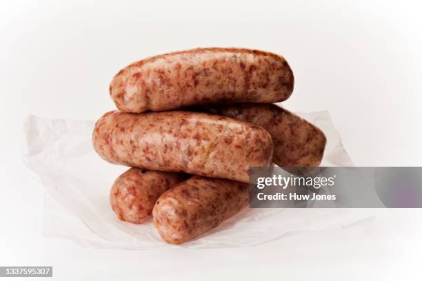 stack of five artisan turkey sausages on a white background with white parchment paper - worst stockfoto's en -beelden