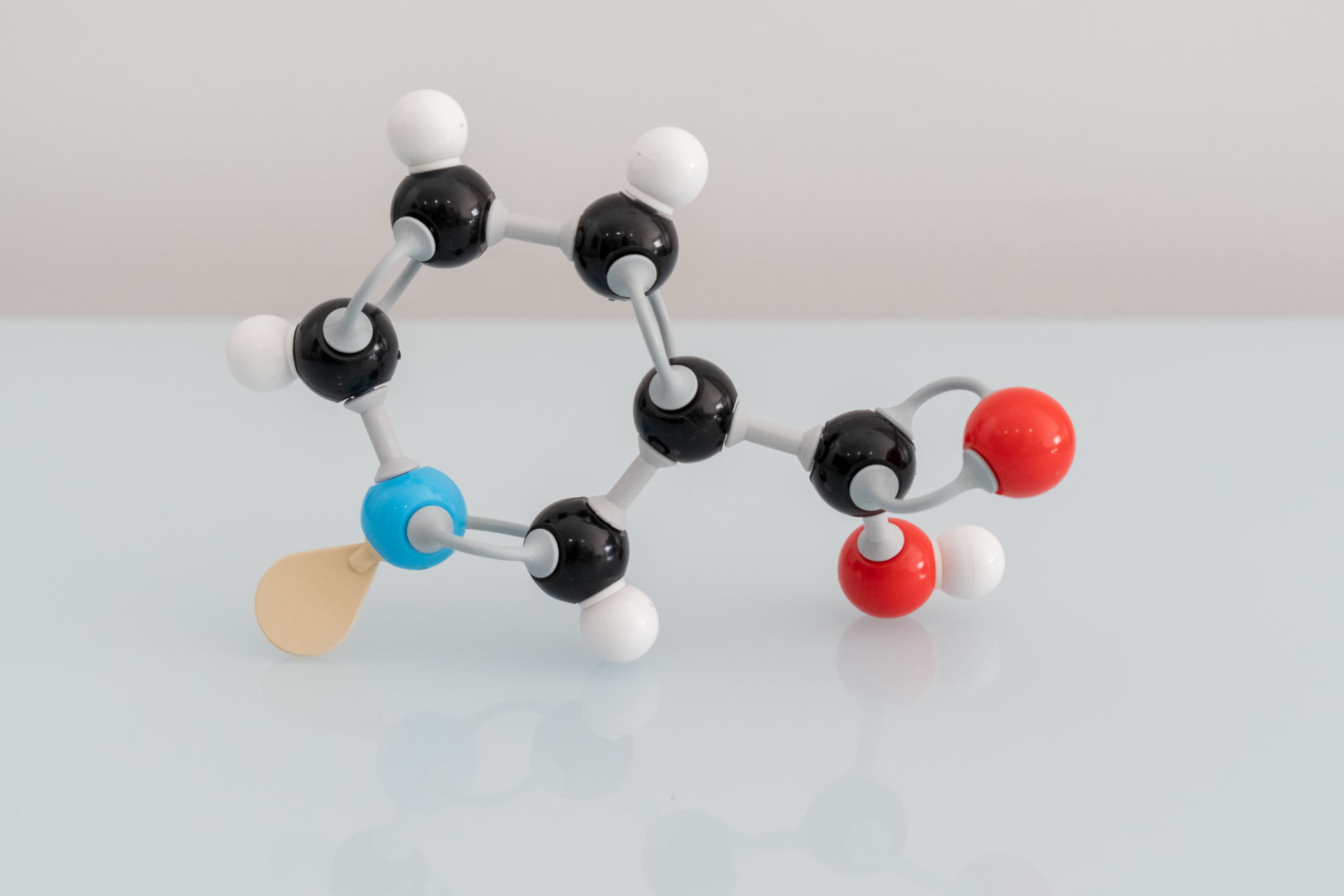 Isolated vitamin B3 made by molecular model with reflection on white background. Niacin chemical formula with colored atoms and bonds Isolated vitamin B3 made by molecular model with reflection on white background. Niacin chemical formula with colored atoms and bonds