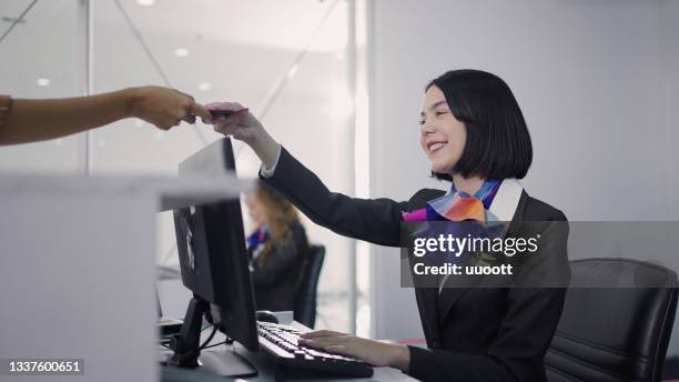 portrait of a female staff at airport check in desk - airport staff stockfoto's en -beelden