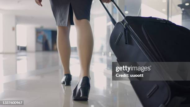 flugbegleiterin geht mit ihrem gepäck am flughafen spazieren - stewardess stock-fotos und bilder