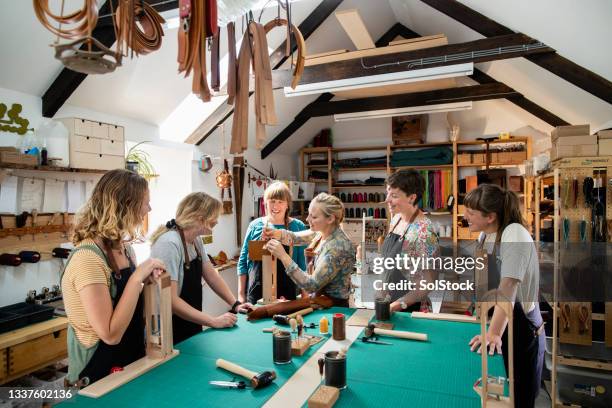 enseigner à un groupe entièrement féminin - travail du cuir photos et images de collection