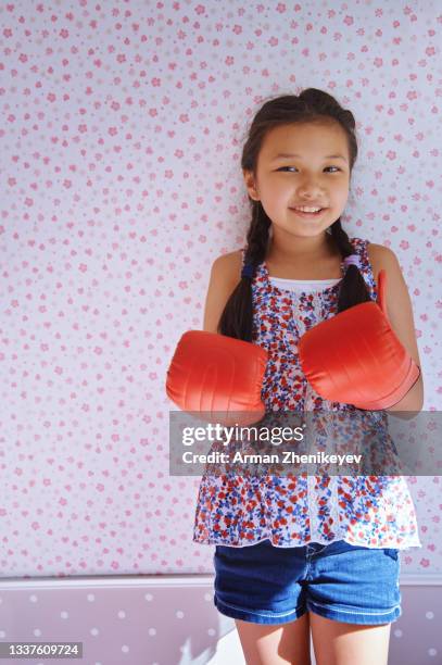 cute girl wearing boxing gloves and standing against the wallpapered wall - funny boxing bildbanksfoton och bilder
