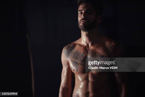 shot of a handsome young man standing alone in the gym during his workout - handsome tattoo stock pictures, royalty-free photos & images