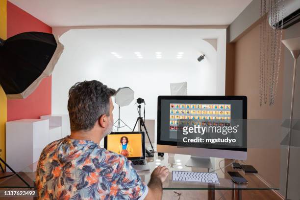photographer sitting in office editing and managing portfolio . - creative director stock pictures, royalty-free photos & images