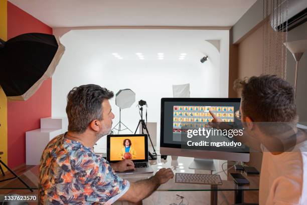 couple of photographers working on computers in the studio - agency stock pictures, royalty-free photos & images