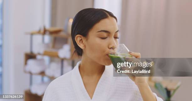 shot of a young woman enjoying a healthy drink at a spa - woman drinking smoothie stock pictures, royalty-free photos & images