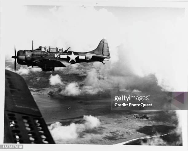 View of Douglas SBD Dauntless , during the 'D-day' landings, as it flies over Tanapag Harbor, Saipan, Marianas Islands, June 15, 1944. The plane was...