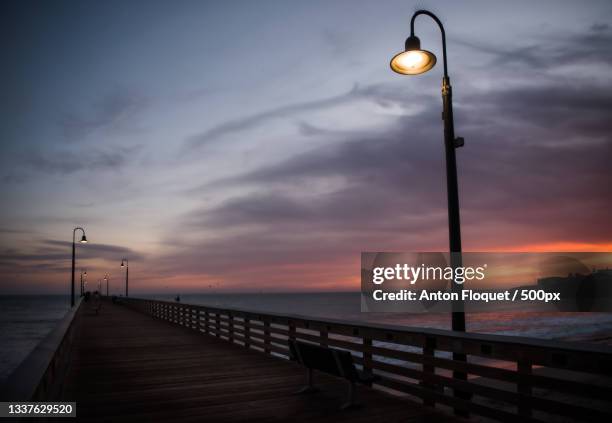 silhouette of pier over sea against sky during sunset,cayucos,california,united states,usa - cayucos stock pictures, royalty-free photos & images