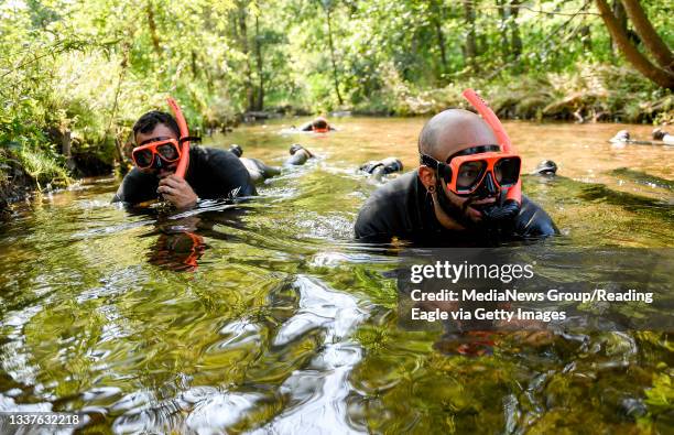 Reading, PA From left are Robin Irizarry, and Jose Santiago, with Audubon Pennsylvania, creek snorkeling while wearing wetsuits snorkels and diving...