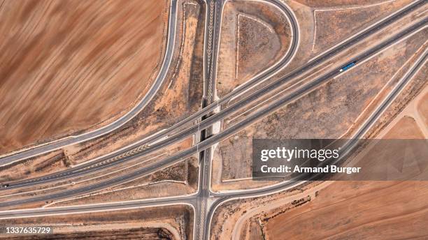 high angle shot of highways along a dry and arid landscape - africa road stock pictures, royalty-free photos & images