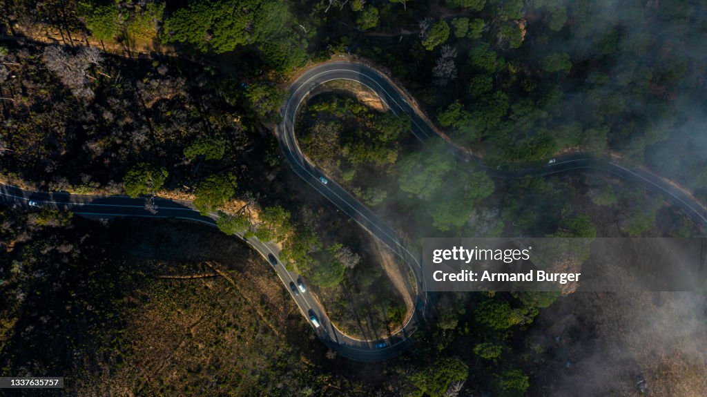 High angle shot of cars travelling on a road through a mountainous area