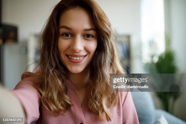 joven sonriente y segura de sí misma que tiene una conferencia en línea desde la oficina en casa - selfie fotografías e imágenes de stock