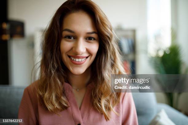 portrait of smiling confident young woman looking at camera - looking to the camera imagens e fotografias de stock