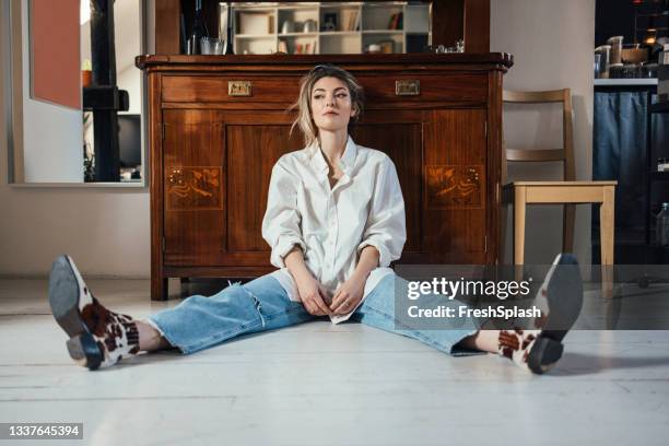 hermosa joven sentada en el suelo - woman boots fotografías e imágenes de stock