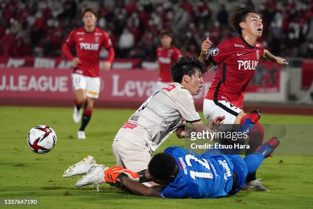 Kai Shibato of Urawa Red Diamonds pushes down Yasuto Wakizaka of Kawasaki Frontale during the J.League YBC Levain Cup quarter final first leg between...
