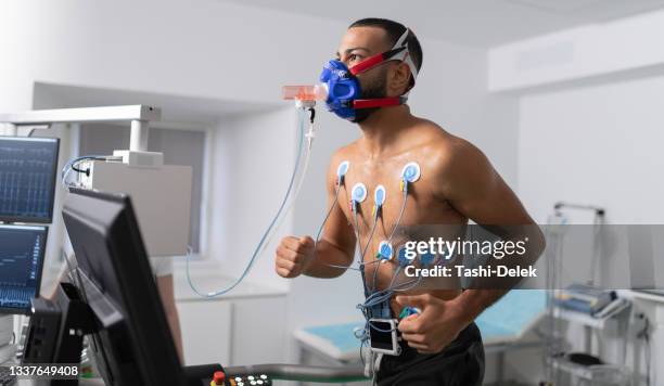 atleta masculino que realiza una prueba de ecg y vo2 en bicicleta de interior - sistema-cardiopulmonar-humano fotografías e imágenes de stock