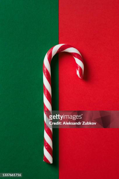 christmas striped candy on a beautiful green and red festive background. copy the space bar. - lollipop fotografías e imágenes de stock