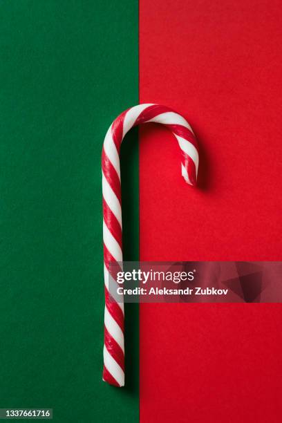 christmas striped candy on a beautiful green and red festive background. copy the space bar. - lolly stockfoto's en -beelden