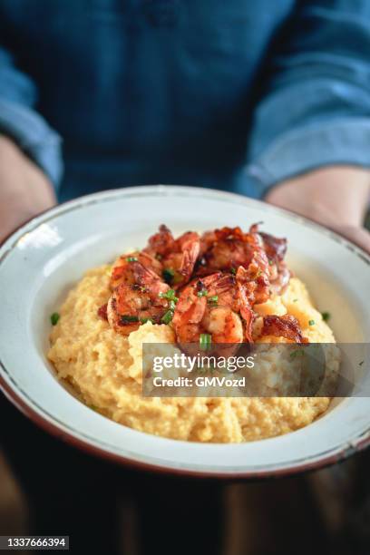 cremige grütze mit garnelen und speck - shrimp and grits stock-fotos und bilder