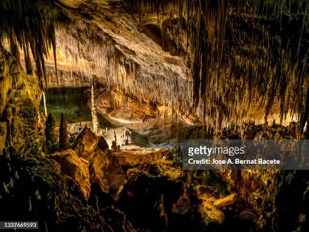 interior of a large cave with an underground lake. - spelunking stockfoto's en -beelden