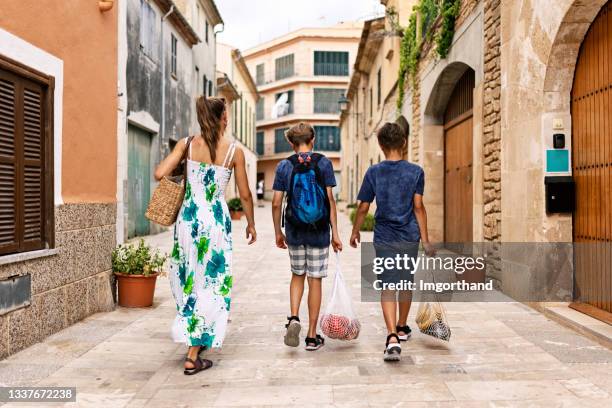 three teenagers carrying shopping home in reusable shopping bags - alcudia stockfoto's en -beelden