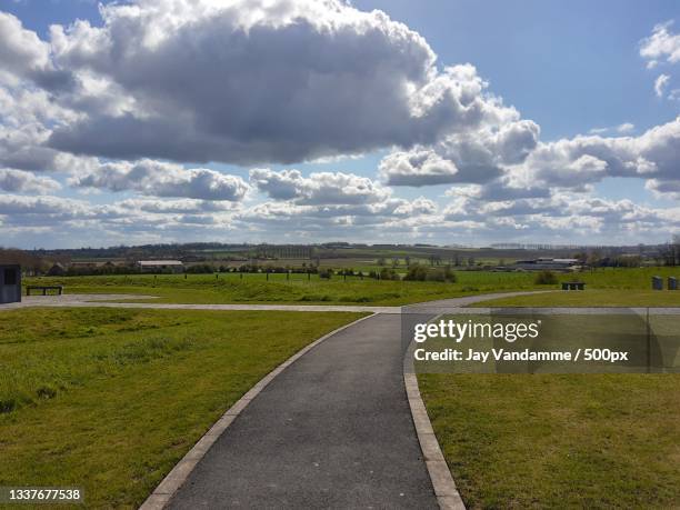 empty road amidst field against sky,west flanders,belgium - fiandre occidentali foto e immagini stock