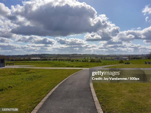 empty road amidst field against sky,west flanders,belgium - west vlaanderen stockfoto's en -beelden