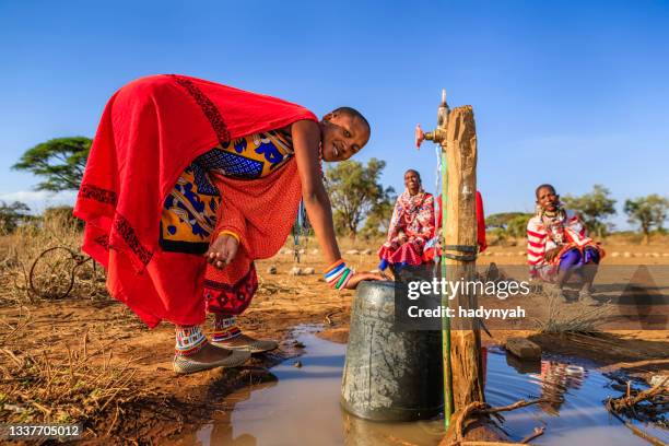 african woman from maasai tribe collecting water, kenya, east africa - kenyansk kultur bildbanksfoton och bilder