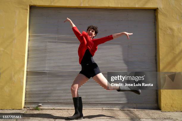 happy woman jumping over urban pavement against wall - salta argentina - fotografias e filmes do acervo