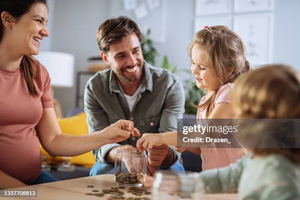 family at home with two girls eating snacks and fruits - couple counting money stock pictures, royalty-free photos & images