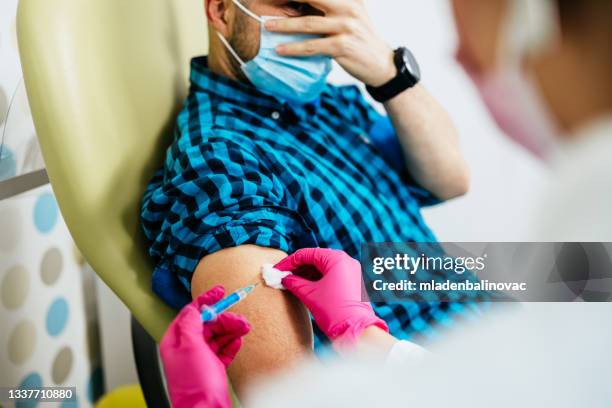 mature man taking a vaccine from his doctor - needle plant part 個照片及圖片檔